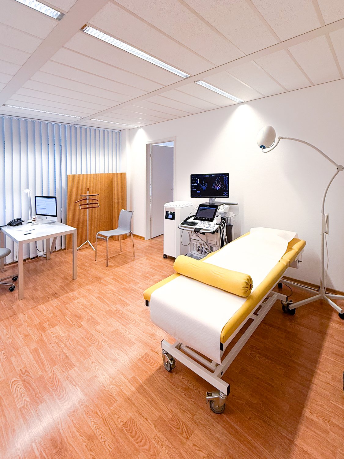 Behandlungszimmer mit Untersuchungsliege, Ultraschallgerät und Untersuchungsleuchte